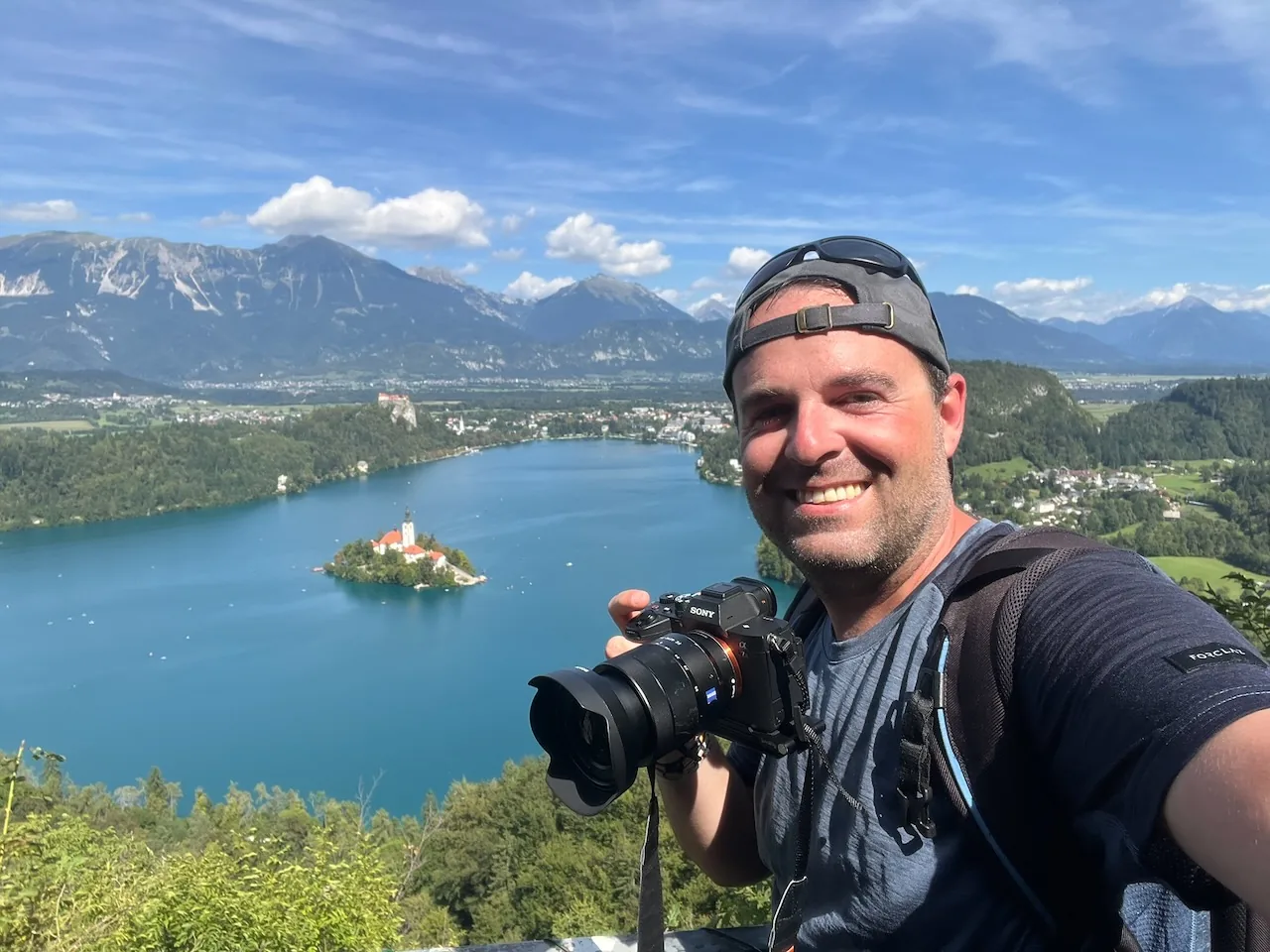Jan Miřacký with camera overlooking Lake Bled in Slovenia
