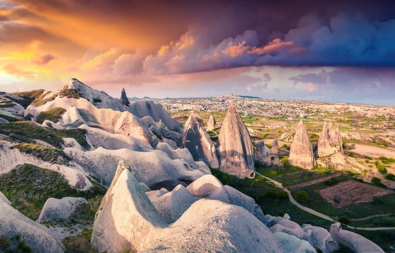 Unreal world of Cappadocia. Dramatic sunrise in Red Rose valley in April. Cavusin village located, district of Avanos in Nevsehir Province in the Cappadocia region of Turkey, Asia. Traveling concept background